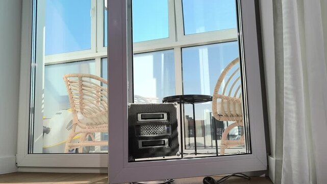 Square robot cleaner washes window corners and edges on glass panel. Automated unit reaches difficult areas while maintaining surface cleanliness. Spring cleaning concept highlights