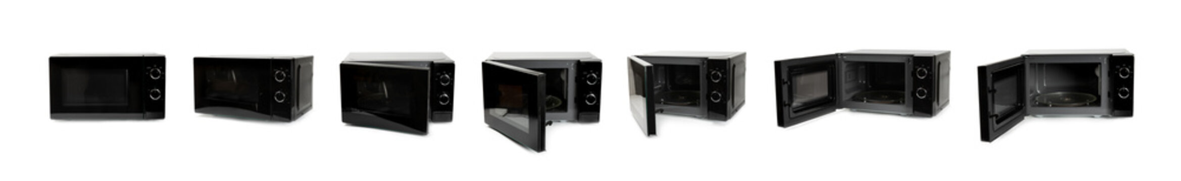 Modern black microwave isolated on white background. Using microwave everyday in the kitchen. The concept of cooking. Microwave oven in modern kitchen interior 