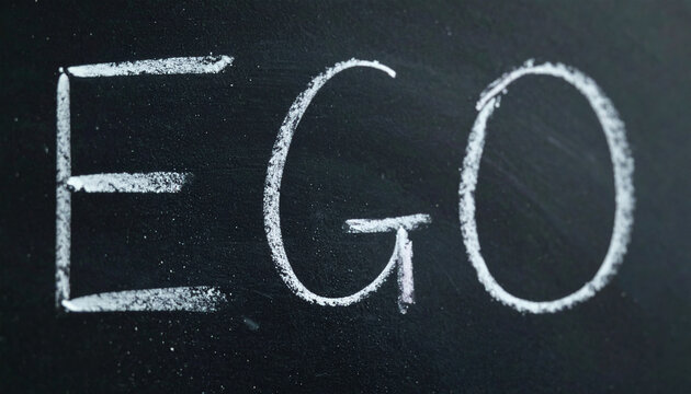 Chalkboard with uppercase word EGO written in chalk, blurred dark background, concept of psychology, identity, self-perception and human behavior