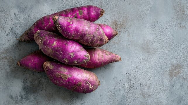 Raw purple ube yam on grey concrete background top view with copy space