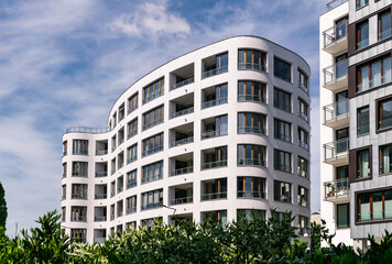Fototapeta premium Beautiful new block house in the blooming garden. Housing development in Europe