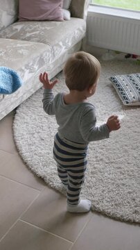 Toddler gradually masters indoor mobility. Young child steadily improves confidence walking inside house. Young child initially moves hesitantly but gradually develops confidence to walk freely inside