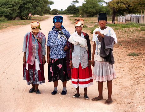 Four Basarwa Women on Dirt Road San people, Botswana. Group walks along a sandy dirt track in the village