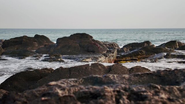 Dramatic slow-motion footage capturing the powerful impact of rising sea levels as ocean waves crash against a rocky shoreline, symbolizing the urgent threat of climate change and global warming