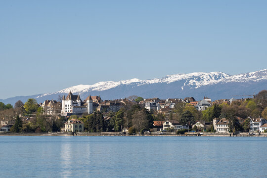 Panorama de Nyon et son ch&acirc;teau depuis le lac L&eacute;man avec le massif du Jura enneig&eacute;.