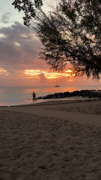 Fire sky at sunset with lone bather at Folkestone marine park, West Coast Barbados Caribbean