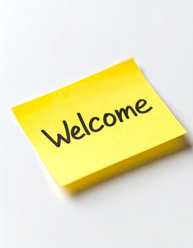 Text WELCOME written on yellow sticky note paper, white background. Greeting, hospitality and invitation.