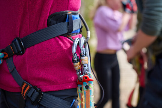 Safety harness with carabiners and lanyard worn by person in outdoor adventure park
