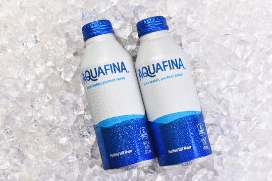 IRVINE, CALIFORNIA - 20 APR 2026: Two aluminum cans of AquaFina purified Still Water on a bed of ice.