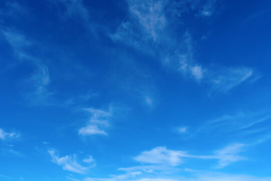 Blue sky wispy white clouds minimal serene horizon background horizontal composition