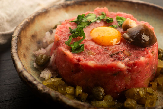 Beef Steak Tartare with Quail Egg on Handmade Ceramic Plate
