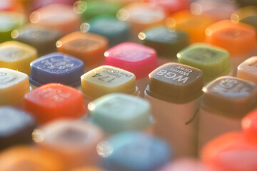 High-angle shot of a vibrant set of professional multi-colored markers arranged on a white workspace, symbolizing creativity, artistic hobby, and design inspiration.