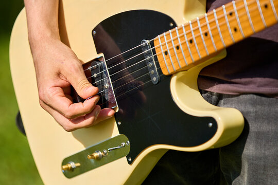 Close-up of telecaster guitar being played by young caucasian male