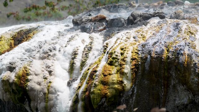 Pai hot springs at Mueang Paeng, North West Thailand, natural hot pools with clear mineral-rich water streams and waterfalls flowing over colorful geothermal surfaces and rocks, nature phenomena.