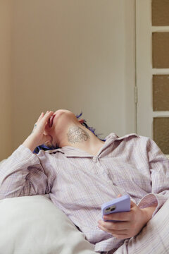 Young person having a good time checking their phone in the morning