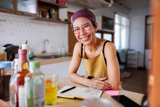 Smiling woman leaning at the kitchen table
