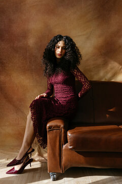 Woman with curly hair sitting on sofa