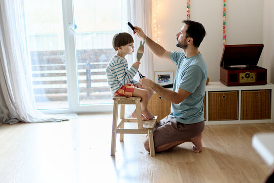 Father giving son a haircut at home