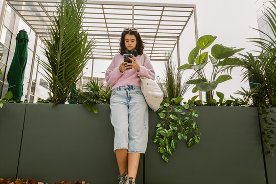 Standing in Garden Phone at Noon