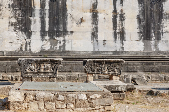 Ancient stone benches and wall carvings at historical ruins site