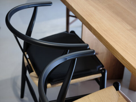 Detail of two black armchairs with a solid wood table