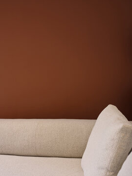 Detail of comfortable sofa with brown wall in a living room