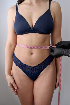 Woman measuring waist with tape
