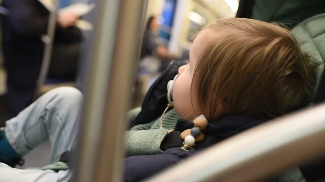Profile portrait of adorable one year old baby boy traveling in subway