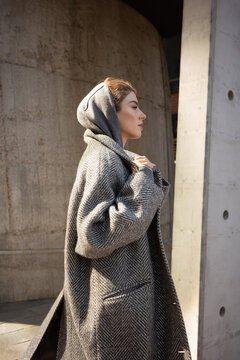 Woman in Wool Coat Walking Along Concrete Wall