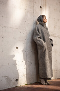 Woman Standing Against Minimal Concrete Wall