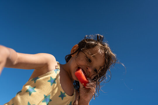 Child enjoying watermelon on the beach