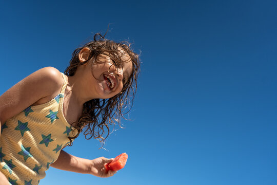 Child enjoying watermelon on the beach