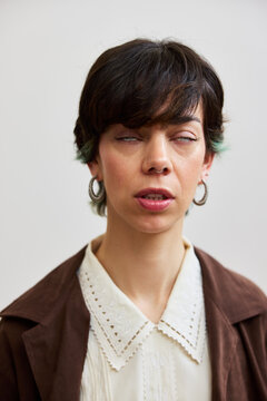 Woman with short hair standing against a plain background