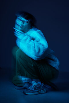 Model poses in blue light with motion effect indoors