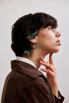 Woman posing thoughtfully against a light background