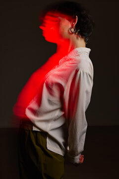 Person standing with red light effect in a dark space