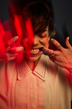 Woman showing strong emotions with red light in dark setting