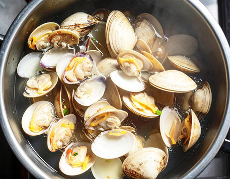 Steamer clams boiling in a large steel pan, top view. AI