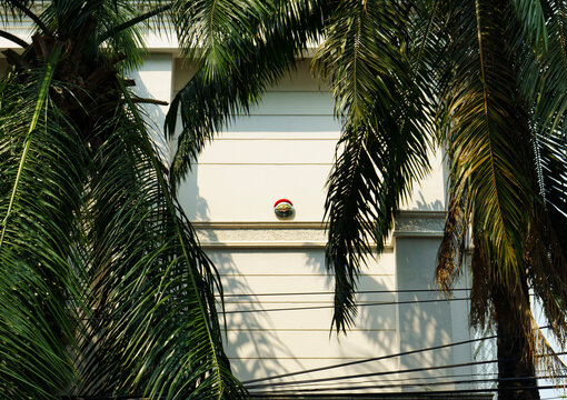 White building with palm trees and Feng Shui decoration at sunset