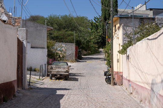 calle con camino de piedra de pueblo m&aacute;gico en m&eacute;xico con vegetaci&oacute;n al fondo y cables