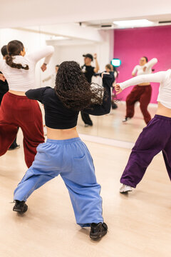 Male instructor teaching urban dance to teenagers in studio