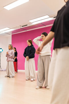 Male instructor teaching urban dance to teenagers in studio