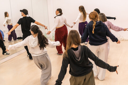 Group of young dancers practicing urban choreography in studio