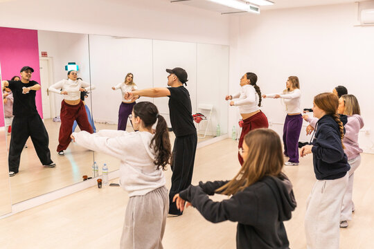 Group of young dancers practicing urban choreography in studio