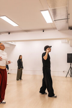 Male instructor teaching urban dance to teenagers in studio