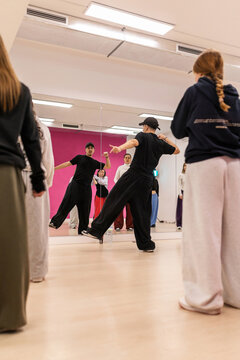 Male instructor teaching urban dance to teenagers in studio