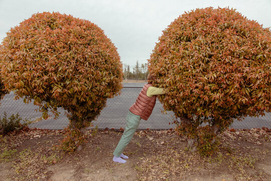 Woman with head in bush