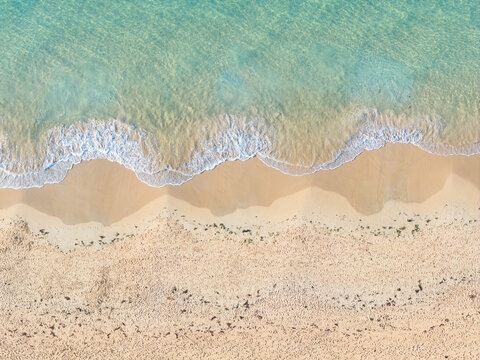 Gentle waves in a shallow sea creating patterns on a sandy beach