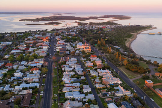 Coastal town surrounded by a calm sea and islands at twilight