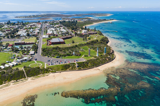 Coastal sports oval and carpark lookout over a sand beach and calm sea